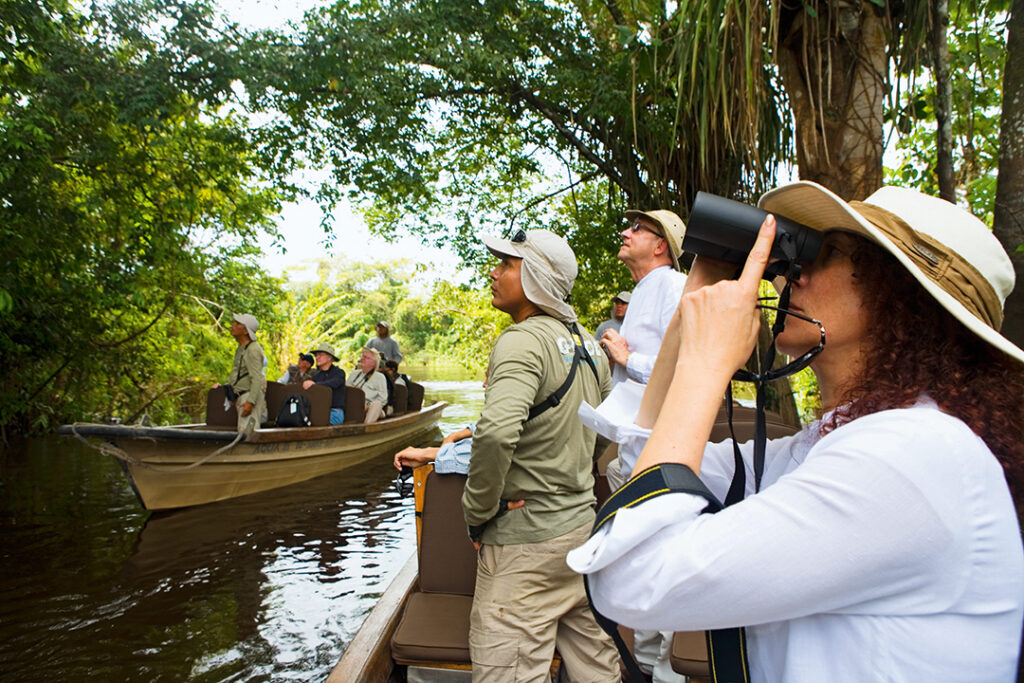 Visitantes observam fauna e flora durante passeio de barco no Amazonas Peruano.