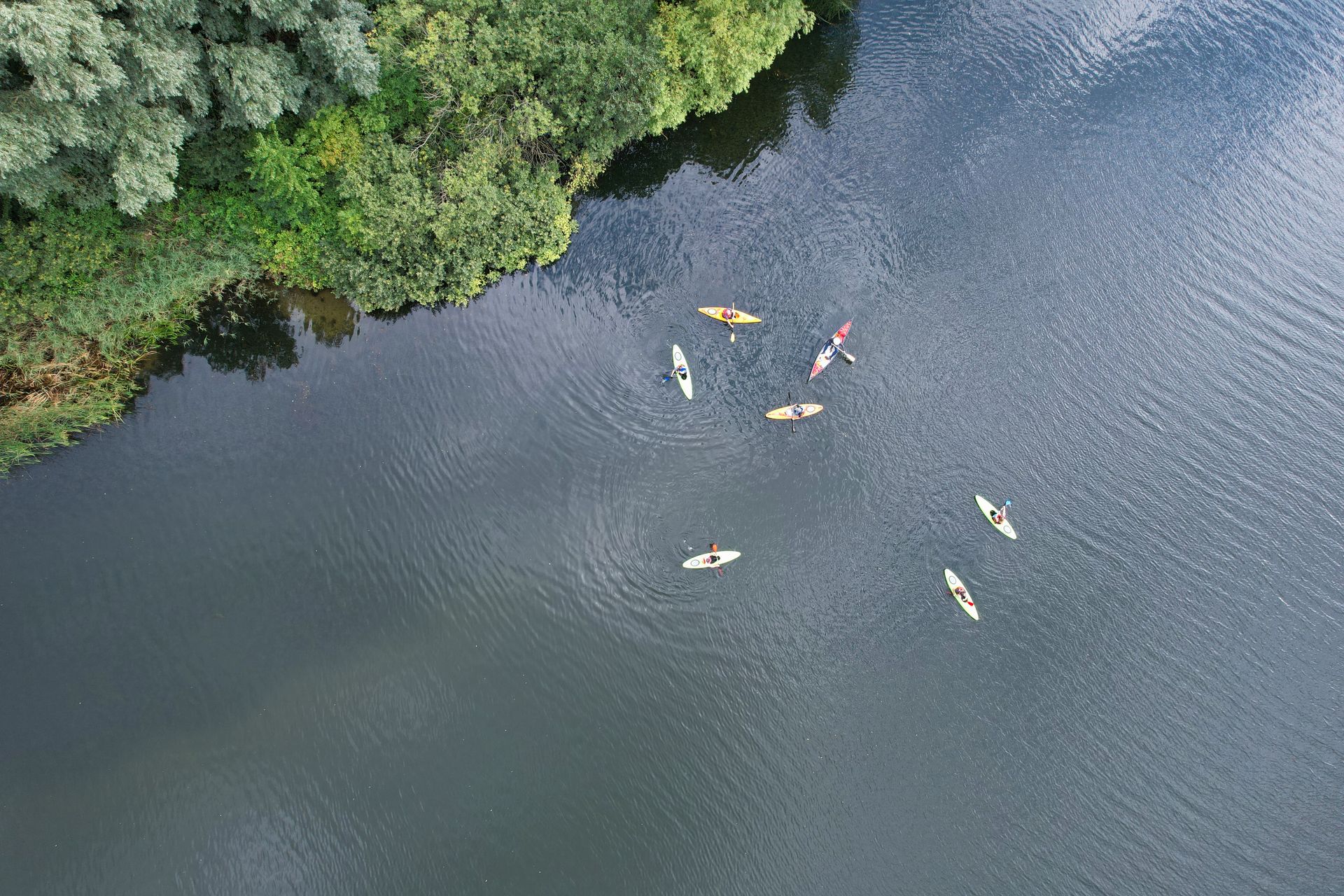 Vista aérea de grupo praticando caiaque e stand up paddle em um rio, simbolizando a aventura na natureza com a Inguz Expedições Fluviais