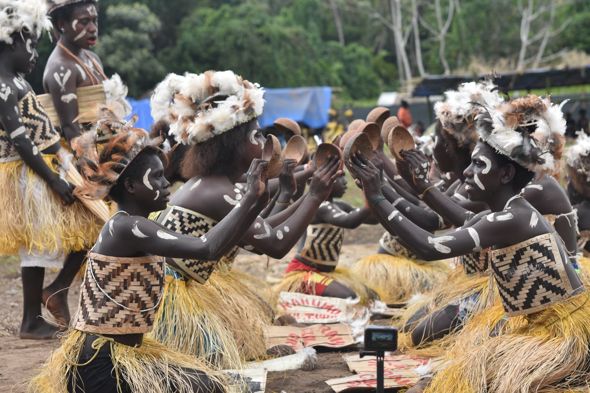 Grupo de pessoas indígenas participando de uma celebração cultural com trajes tradicionais, destacando a imersão cultural proporcionada pela Inguz Expedições Marítimas.